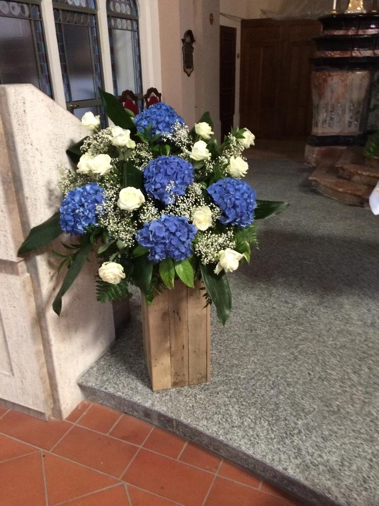 Composizione di ortensie blu e rose bianche in chiesa