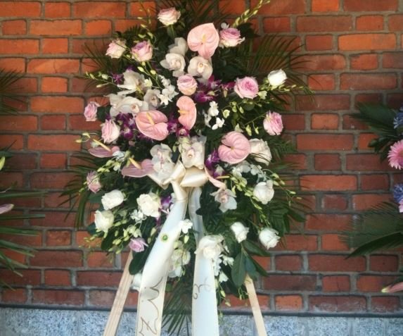 Composizione funebre di rose e anthurium chiari su cavalletto