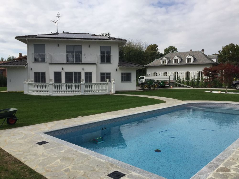 Prato rasato davanti a una villa con piscina